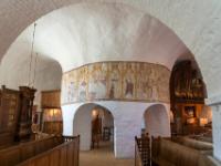 Kirchenschiff in Østerlars Rundkirche mit mächtiger, durchbrochener Mittelsäule mit Malereien - Østerlars